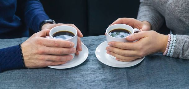 Man and woman at the table with a cup of coffee. Selective focus. People. - 写真・画像
