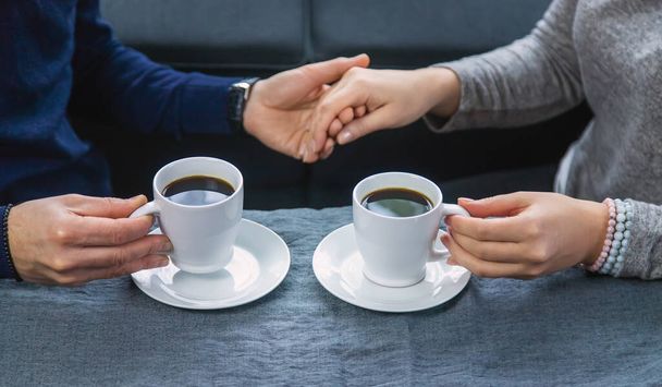 Homme et femme à table avec une tasse de café. Concentration sélective. Les gens. - Photo, image