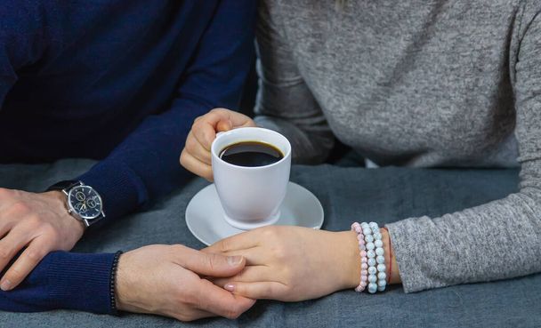 Man en vrouw aan tafel met een kop koffie. Selectieve focus. Mensen. - Foto, afbeelding
