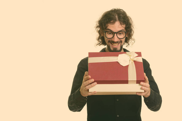 Onnellinen komea valkoihoinen mies avaamassa lahjapakkausta valmis Ystävänpäivä - Valokuva, kuva