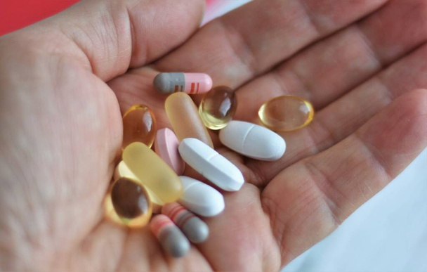  Medikamente, Tabletten und Kapseln in der Handfläche einer Frau - Foto, Bild