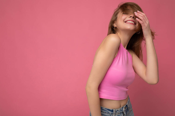 Foto de atractiva linda mujer joven emocional feliz posando aislado en la pared de fondo con espacio libre con ropa casual de moda - Foto, Imagen