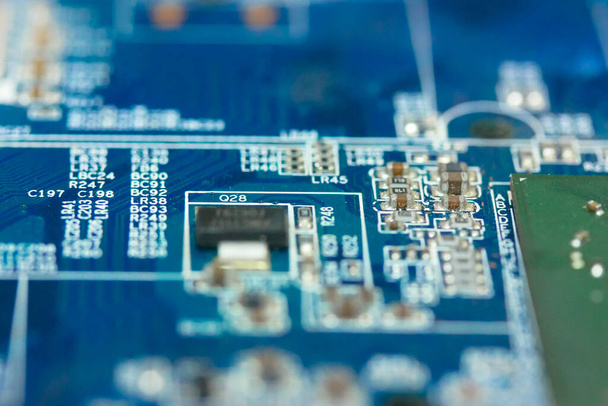 O reverso do microboard em um fundo azul. Placa eletrônica com componentes elétricos, equipamentos de computador. Foto de alta qualidade - Foto, Imagem