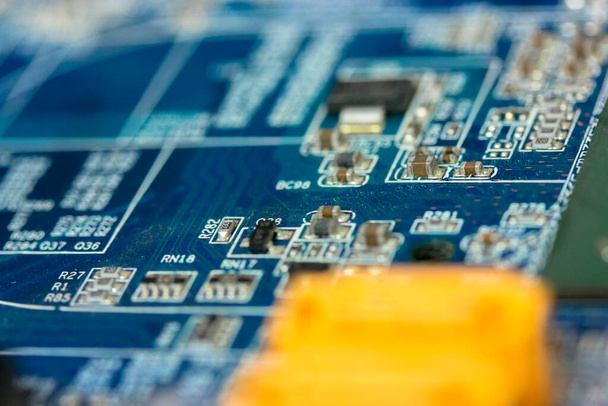 El reverso del colorido microboard sobre un fondo azul. Tablero electrónico con componentes eléctricos, equipo informático.. Foto de alta calidad - Foto, imagen