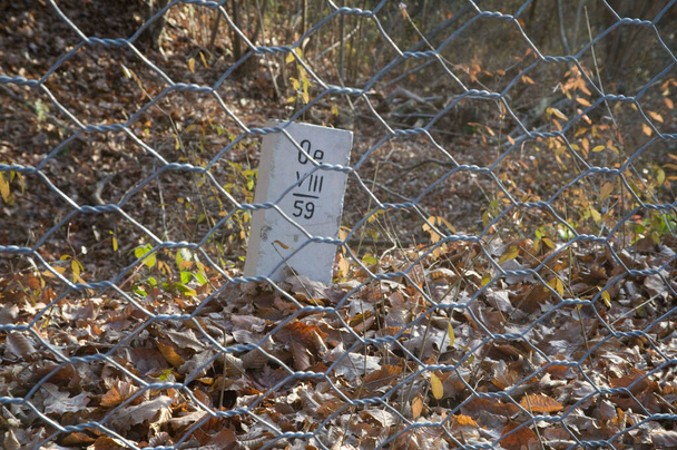 una piedra fronteriza y una valla en la frontera estatal - Foto, Imagen