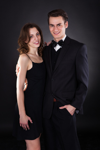 Elegant Couple Standing Over Black Background - Foto, immagini
