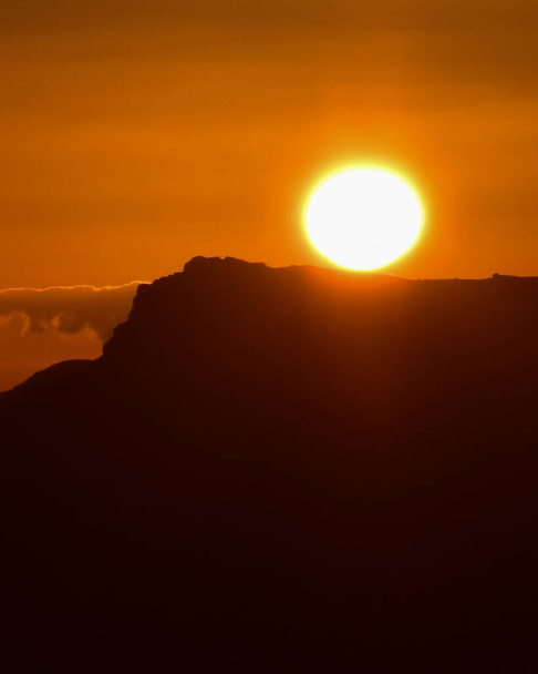 Puesta de sol con cielo naranja y silueta de montaña - Foto, imagen