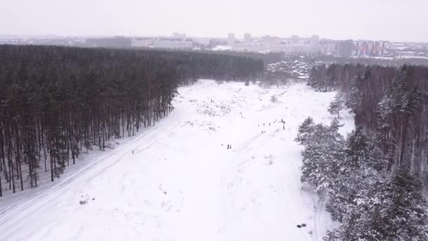 Widok z powietrza tłum ludzi na zajęcia rekreacyjne w dolinie w sezonie zimowym - Materiał filmowy, wideo