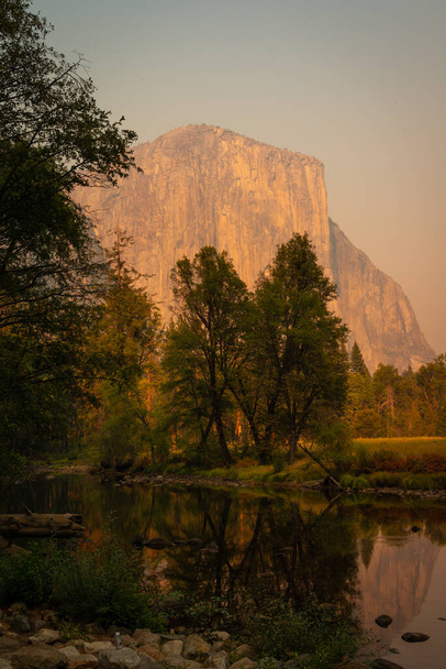 El Capitan lit up by setting sun and Merced River in foreground - Foto, afbeelding