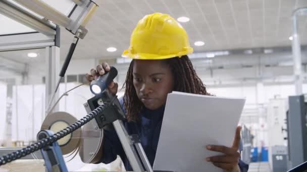 Αφρο-Αμερικανός μηχανικός ελέγχει τον εξοπλισμό με έγγραφα - Πλάνα, βίντεο