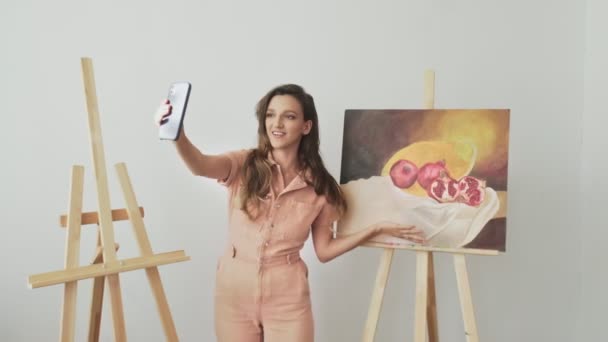 Όμορφη καλλιτέχνης κάνει ρεκόρ βίντεο ιστορίες μαζί της μια νέα εικόνα στο εργαστήριό της - Πλάνα, βίντεο