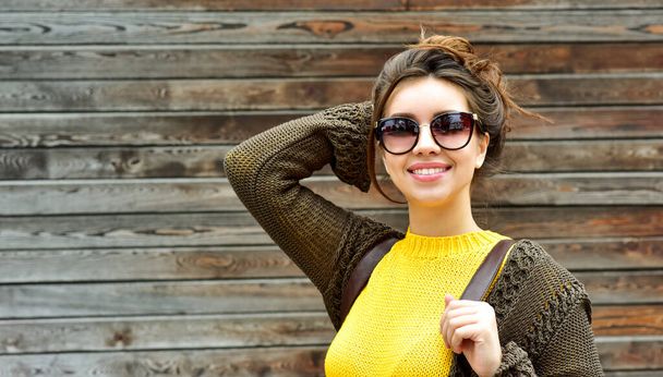 Beautiful smiling brunette woman with luxurious hair over wooden background. Autumn time. Fall season. - Фото, зображення