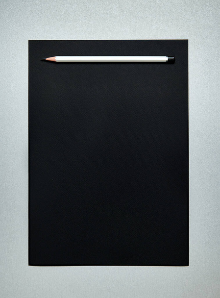 Wooden pencil on a black paper. Office tools. Top view. Flat lay - Foto, immagini