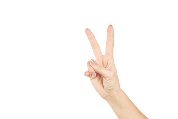egy nő, aki két ujjat mutat, fehér alapon elszigetelve. Másolás. győzelem és béke gesztus koncepció - Fotó, kép