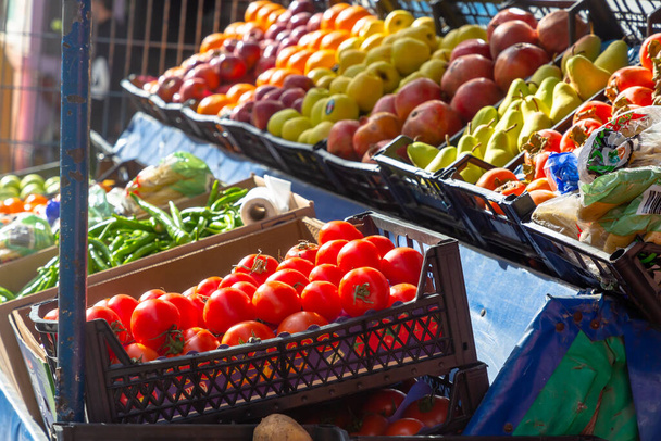 Vegetables and fruits: tomatoes, peppers, apples, pears in a vegetable shop on the street. - Foto, Imagem