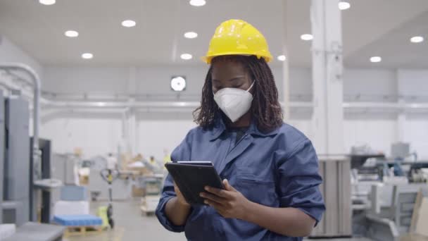 Femme travailleuse d'usine noire portant un masque facial - Séquence, vidéo