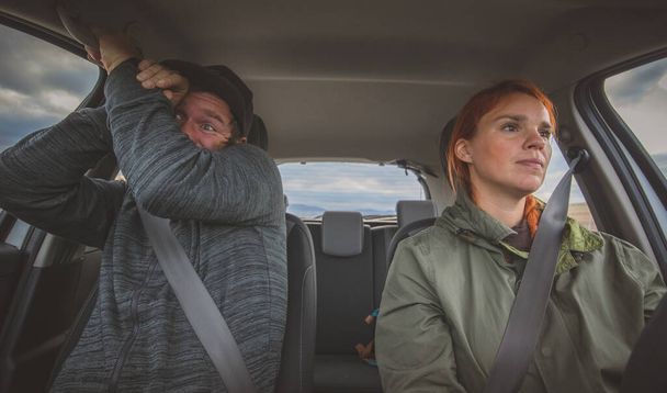 Eine Frau fährt ruhig Auto und ein Mann auf dem Nebensitz hat höllische Angst. Völlig verängstigte Beifahrerin wegen rücksichtsloser Fahrweise einer Frau. - Foto, Bild