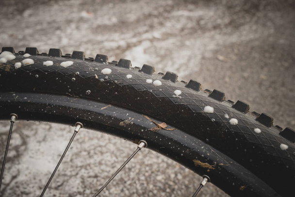 Perforated or punctured mountain bicycle tire, with visible foam escaping through perforated holes. Tubeless system on a bicycle sealing tire wall which is perforated. - Foto, immagini