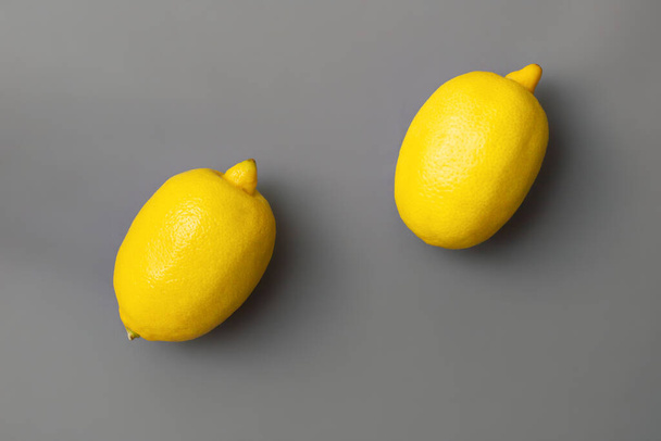 Gri arka planda sarı limonlar. Yılın Renkleri 2021 Pantone Aydınlatıcı ve Nihai Gri, düz, kopyalama alanı - Fotoğraf, Görsel