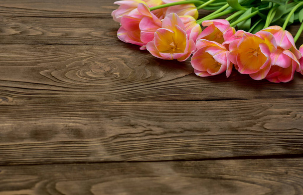 Spring tulip flowers over wooden background. Pink tulips. - Foto, afbeelding