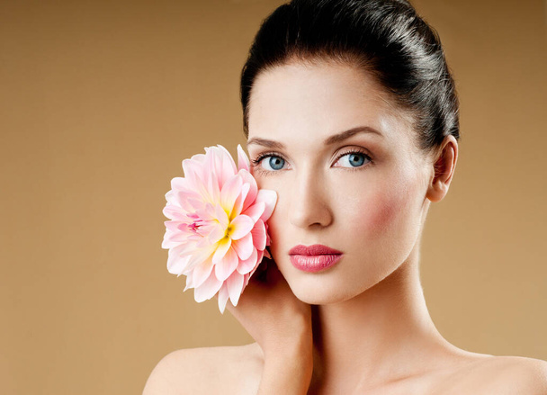 beautiful woman with pink flower. perfect skin. fashion model with   flowers. Professional makeup. - Foto, Imagen