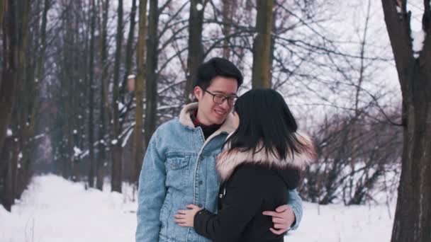 Heureux jeune couple asiatique embrasser sous l'arbre couvert de neige. Amour et affection de la saison hivernale. Saint Valentin - Séquence, vidéo