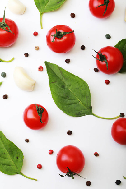 Tomato, basil, spices, pepper, garlic. Vegan diet food, creative cherry tomato composition isolated on white. Fresh basil, herb, tomatoes, cooking concept, top view. - Foto, imagen
