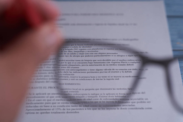 reading a piece of writing through the optical lens, focus and defocusing. close-up detail of the gaze of a lens on a piece of paper with medical indications - Photo, Image