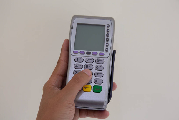 Mužská ruka číselníky pin kód na pin pad karty stroje nebo terminálu s vloženým prázdné bílé kreditní - Fotografie, Obrázek