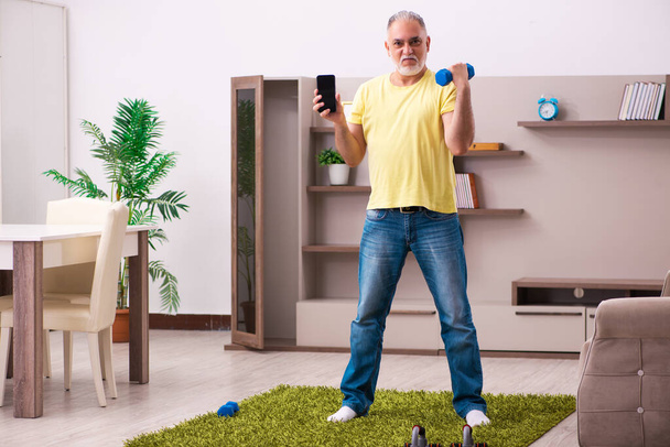 Ηλικιωμένος κάνει αθλητικές ασκήσεις στο σπίτι - Φωτογραφία, εικόνα