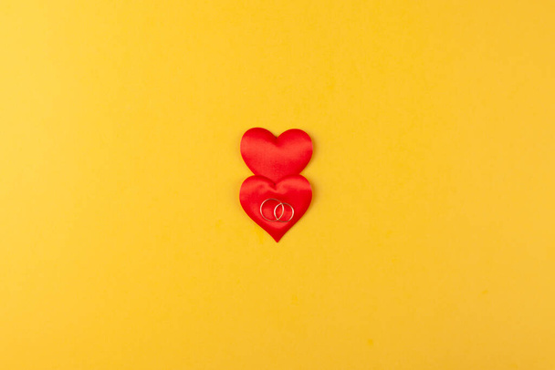 Dwa złote pierścionki na czerwonych sercach, koncepcja miłości, dar, propozycja małżeństwa - Zdjęcie, obraz
