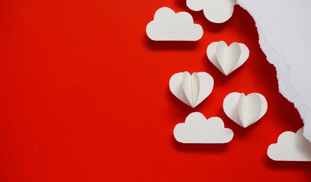Valentine έννοια φόντου με λευκό χαρτί κομμένο σε σχήμα καρδιάς τοποθετείται σε κόκκινο φόντο - Φωτογραφία, εικόνα
