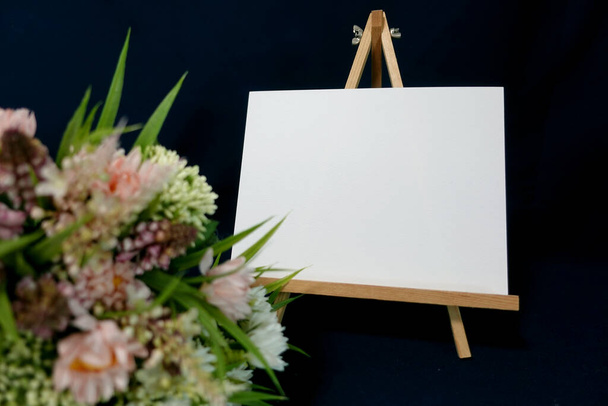 Biała, bezduszna mieszanka pięknych kwiatów i białych papierowych liter na sztalugach z okazji rocznicy - Zdjęcie, obraz