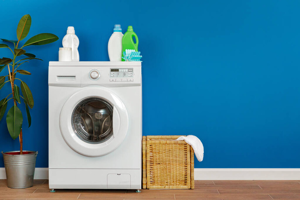 Washing machine with laundry on blue wall background - Φωτογραφία, εικόνα