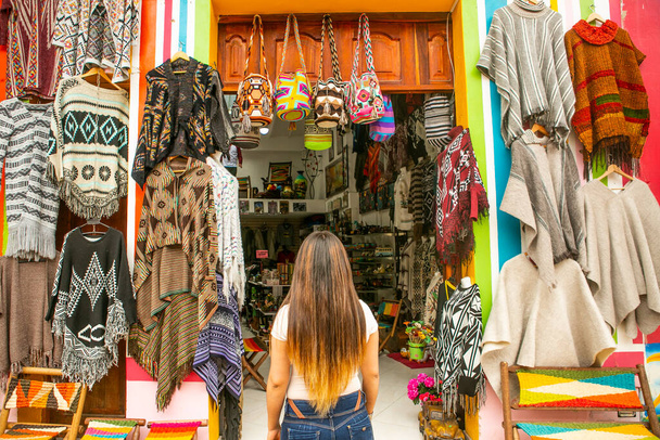 De souvenirwinkel in het oude Spaanse koloniestadje Solento van Colombia, Zuid-Amerika en een dame op zoek naar een souvenir - Foto, afbeelding