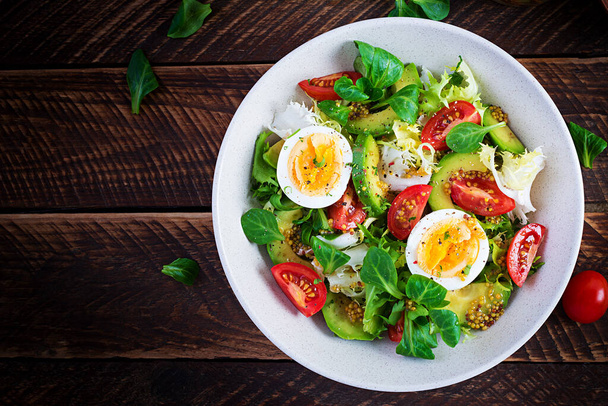Φρέσκια σαλάτα αβοκάντο με ντομάτα, αβοκάντο, βραστά αυγά και φρέσκο μαρούλι. Κετογόνο πρωινό δίαιτας. Κέτο, σαλάτα παλέο. Κάτοψη, από πάνω, πάνω - Φωτογραφία, εικόνα