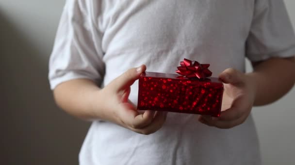 O rapaz dá um presente vermelho, dia dos namorados. Presente de Natal. - Filmagem, Vídeo