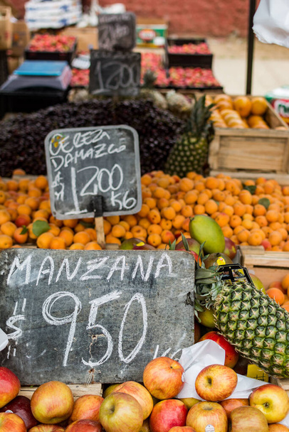 Pystysuora lähikuva laukaus omenoita, ananaksia, appelsiineja ja muita hedelmiä myynnissä markkinoilla - Valokuva, kuva