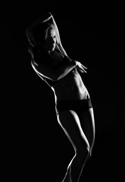 Beautiful female body on a dark background - Foto, Imagem