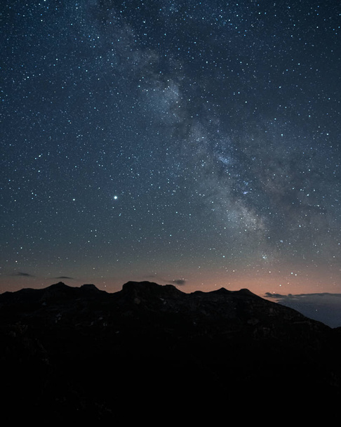 The magical starry night sky over the rocky mountains - Photo, Image