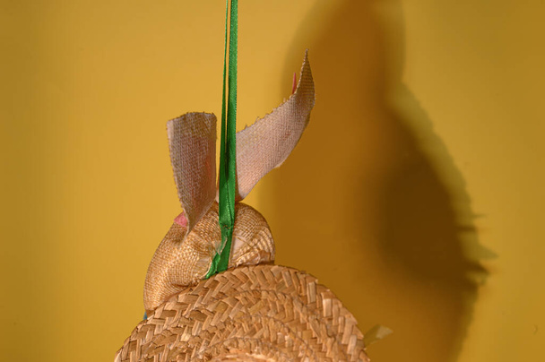διακοσμητικό πασχαλινό λαγουδάκι από ψάθινο καπέλο σε ανοιχτό φόντο, κοντινή θέα, χαρούμενη ιδέα Πάσχα  - Φωτογραφία, εικόνα