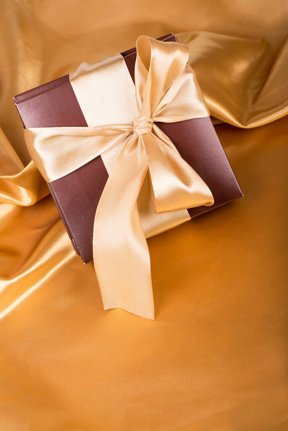 brown box with candies and golden tape close up - Foto, imagen
