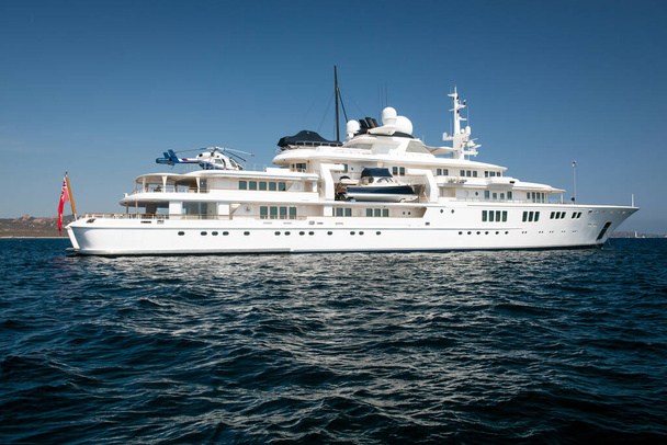 Large luxury super motor yacht with helicopter on the top deck in the blue sea - Foto, afbeelding