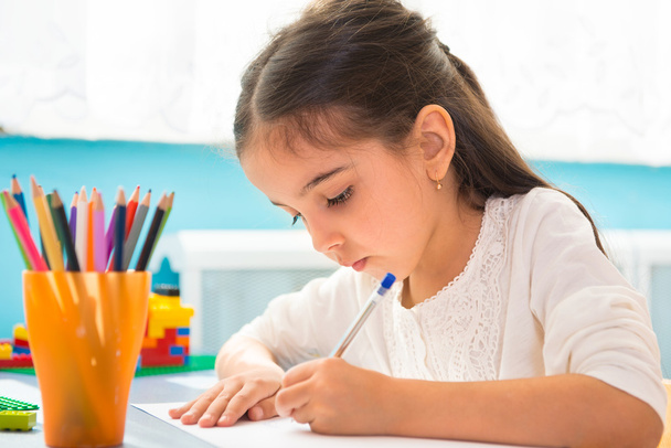 Cute hispanic girl writing at school - Фото, изображение