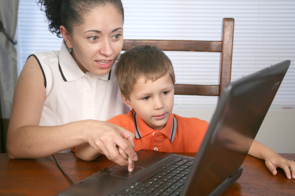 A mother and her child looking at a laptop - Фото, изображение