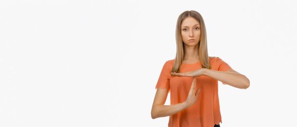 Mujer rubia joven con ropa casual mostrando el gesto del tiempo fuera. Emociones humanas, concepto de gesto. Captura de estudio, fondo blanco - Foto, imagen