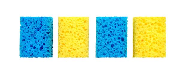 Esponjas de lavado porosas rectangulares azules y amarillas aisladas sobre un fondo blanco - Foto, Imagen