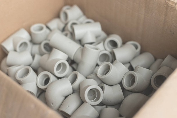 Fittings for installation of water supply from polypropylene in carton. White plastic tees for connecting branches in the water supply system - Photo, image