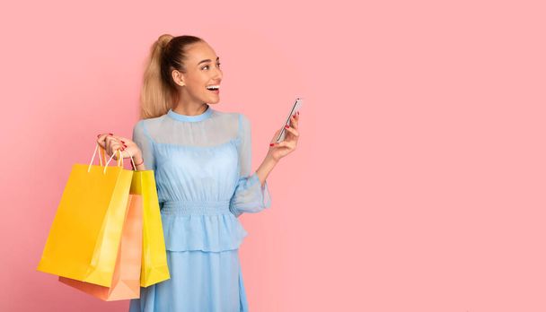 Mulher feliz segurando celular e sacos de compras - Foto, Imagem