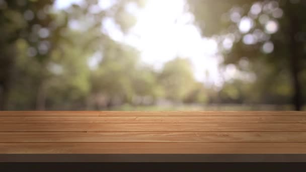 Tisch und Stuhl, Holz Tisch Bar und Natur Baum Bokeh verschwommenen Hintergrund in der Morgenzeit und schöne Natur Sonnenlicht, oben Holz Tisch Raum für Produkte zeigt. 3840x2160. 4k uhd. video clip. - Filmmaterial, Video
